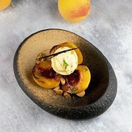 Melocotones asados, crumble de nueces, toffe y helado de vainilla