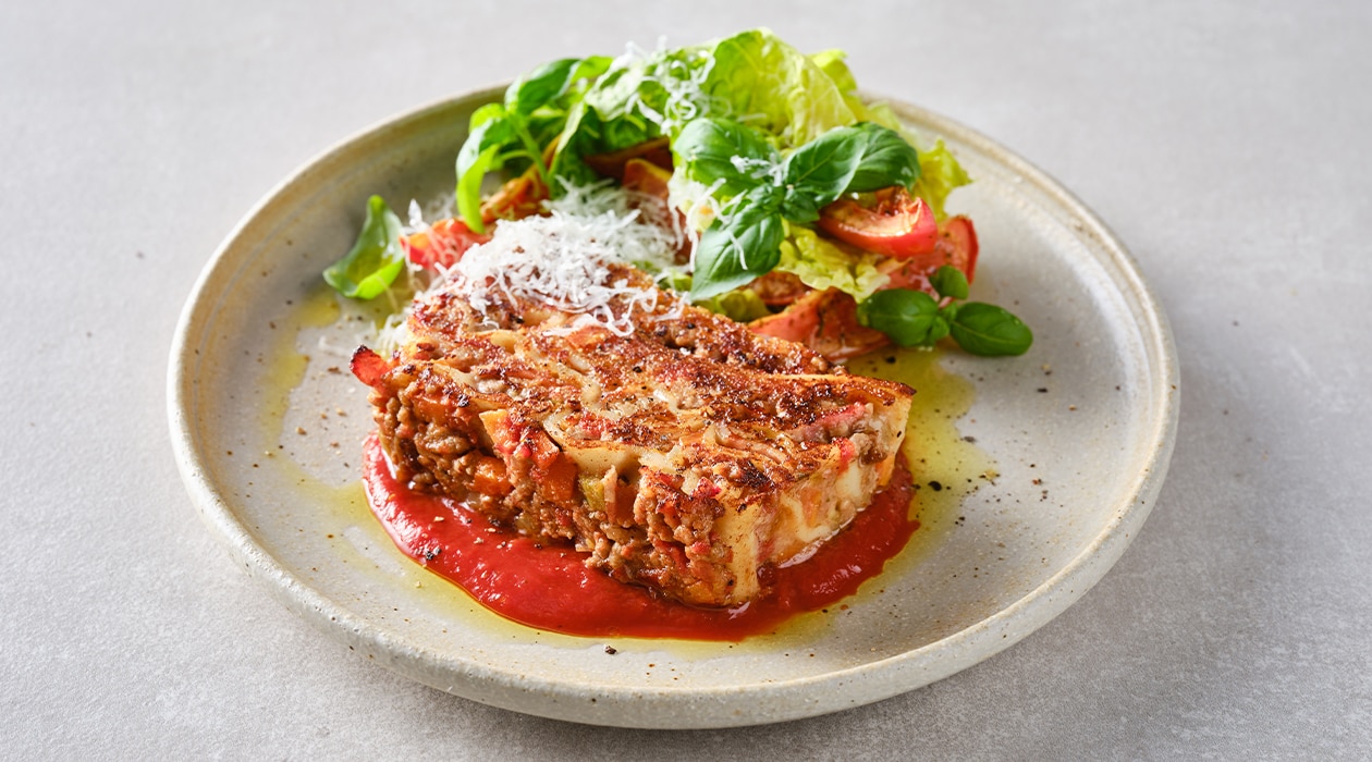 Lasaña en porciones, doble horneado, servida con ensalada fresca – - Receta - UFS