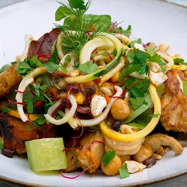 Trozos de Nopollo al ajillo fritos con ensalada de verduras de colores Trozos de Nopollo al ajillo fritos con ensalada de verduras de colores