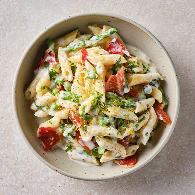 Pasta cremosa con espárragos verdes, guisantes, estragón y crujiente de jamón