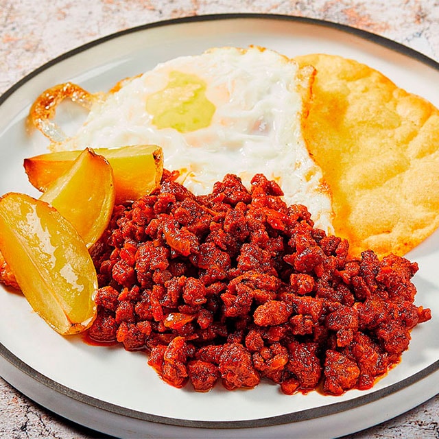 Picadillo vegano, con huevo frito y pan de maíz crujiente Picadillo vegano, con huevo frito y pan de maíz crujiente