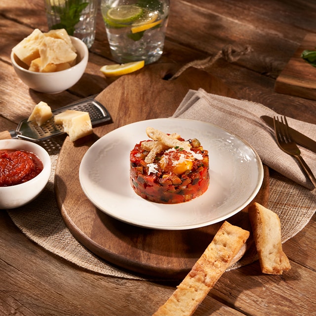 Ratatouille en timbal con crujiente de pan y yema curada Ratatouille en timbal con crujiente de pan y yema curada