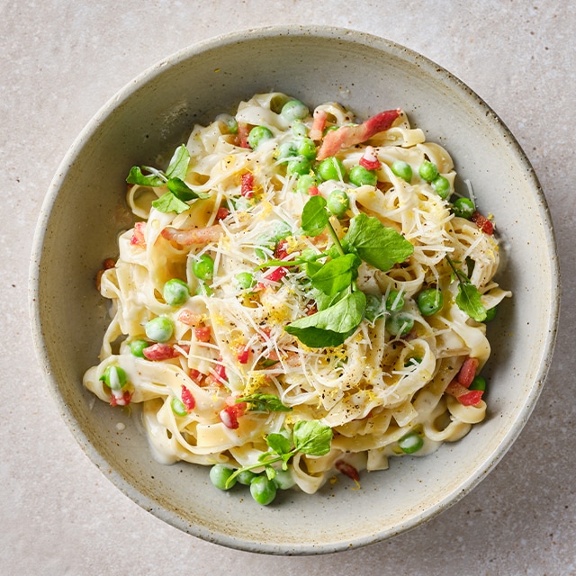 Tagliatelle cremosos con guisantes, ajo, parmesano y panceta crujiente Tagliatelle cremosos con guisantes, ajo, parmesano y panceta crujiente